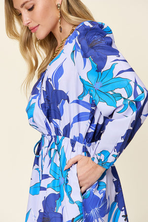 Blue floral wrap romper with long sleeves and cinched waist