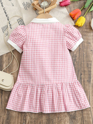 Baby pink gingham cotton polo dress with short puff sleeves and ruffle hem.