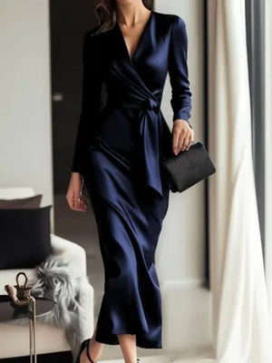 Luxurious satin tie-waist dress in dark blue with V-neck and long sleeves.