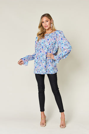 Painterly print blouse in sky blue with gathered long sleeves and a round neckline.