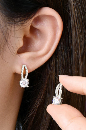 Sparkling silver stud earrings with a single round moissanite stone and pave detail.
