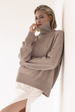 Oversized taupe cashmere turtleneck sweater with ribbed cuffs and hem.
