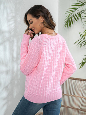 Pink crewneck knit sweater with textured pattern and button detail
