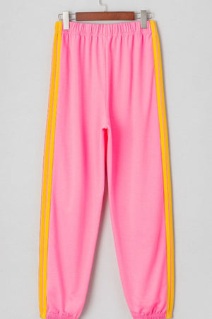 Pink track pants with yellow double stripes down the sides.