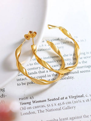 Gold twisted hoop earrings with a sculpted design.