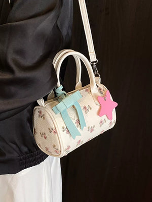 Charming floral mini crossbody bag with bow and star charm, barrel shape, adjustable strap