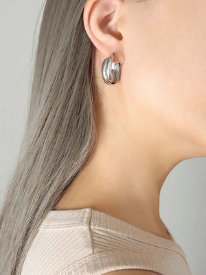 Sculpted silver double-band hoop earrings with a modern, layered design.