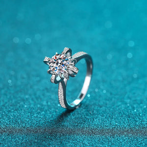 Sterling silver ring with a sparkling floral-shaped center stone and pave band.