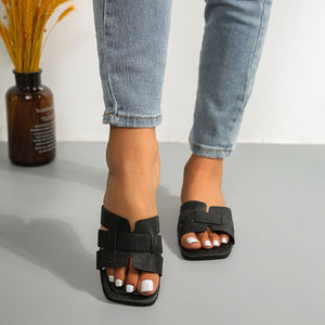 Black woven strap flat sandals with chic square toe design.