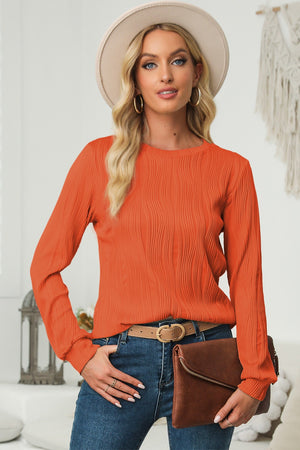 Orange crewneck pullover with textured wave pattern and long sleeves.