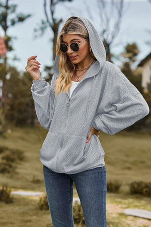 Light Gray textured cable knit zip-up hoodie with pockets and a hood.