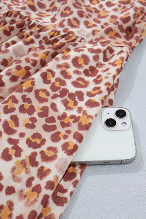 Leopard print dress with ruffled detail and a V-neck, shown with a phone in the pocket.