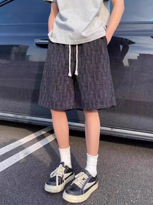 Black textured drawstring casual shorts with basketweave pattern and white tie.