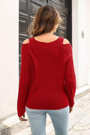 Red cable knit sweater with cold shoulder detail and V-neckline.