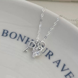 Sterling silver necklace with heart lock and key charms, featuring a cubic zirconia heart.