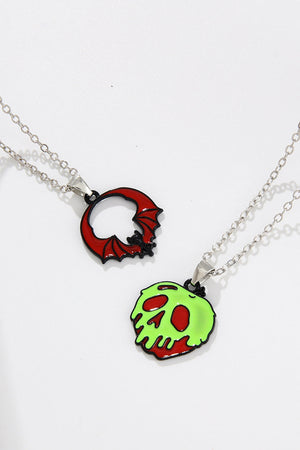 Spooky Season enamel pendant necklaces, one red bat, one green skull with red accents.