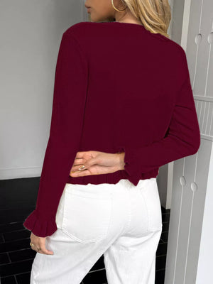 Burgundy knit cardigan with ruffled trim at hem and cuffs.