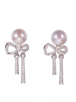Luminous bowknot pearl drop earrings with crystal accents and silver metal.