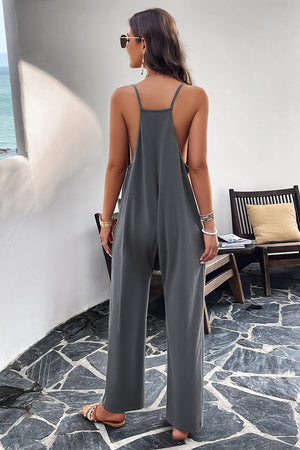 Dark gray relaxed drape pocket jumpsuit with wide legs and spaghetti straps.