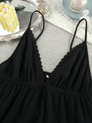 Black cotton tiered mini dress with lace trim V-neck and adjustable spaghetti straps.