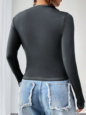 Dark gray long sleeve fitted graphic top with white contrast stitching detail.