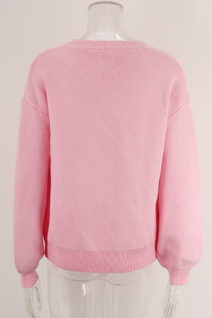 Blush pink acrylic knit sweater with graphic bow intarsia detail and crew neck.