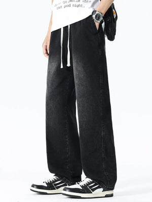 Relaxed wide leg black denim jeans with drawstring waist and pockets.