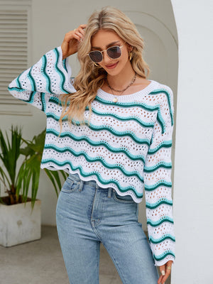 Scalloped crochet crop sweater in white with turquoise wave pattern, bell sleeves, and round neck.