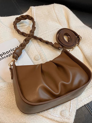 Brown ruched crossbody bag with braided strap and adjustable shoulder strap.