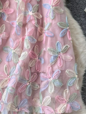 Pink layered skirt with embroidered pastel floral appliques and sequin details.