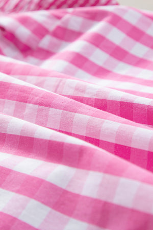 Fuchsia pink and white gingham blouse with ruffle sleeves.
