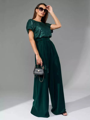 Dark green sequin wide-leg jumpsuit with tie waist and short sleeves.