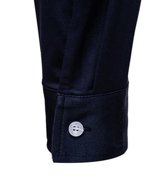 Men's navy blue button-up shirt cuff detail with white button.