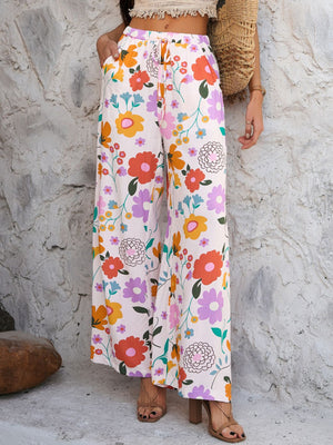 Geometric print wide-leg trousers with drawstring waist and pockets in multicolor floral pattern.