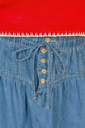 Denim a-line skirt with button front, tie waist, and ruffle hem.
