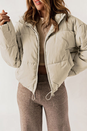 Taupe cropped puffer jacket with hood, full zip, and drawstring hem.