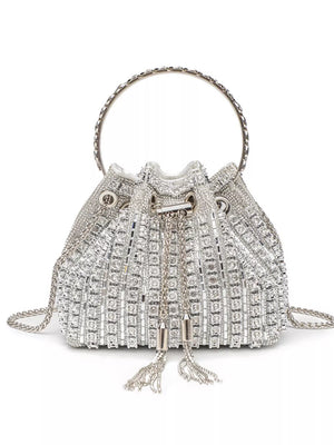 Silver rhinestone embellished mini crossbody bucket bag with chain strap and tassels.