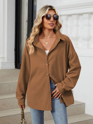 Oversized corduroy shirt jacket in brown with button front and collar, styled with jeans.