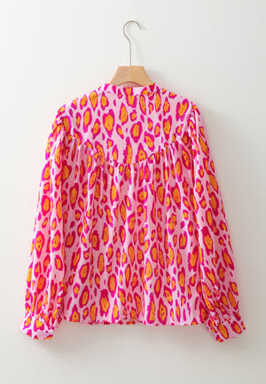 Pink leopard print blouse with balloon sleeves and a mock neck.