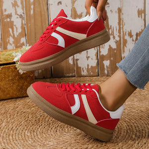 Red suede platform sneakers with curved cream and white stripes and gum soles.