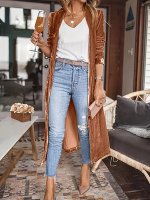 Terracotta velvet duster coat with fluid silhouette, open front, long sleeves, worn with jeans.