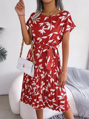 Crimson leaf print midi dress with tie waist and pleated skirt.