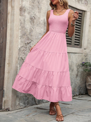 Pink smocked bodice tiered maxi dress with square neckline and sleeveless design.