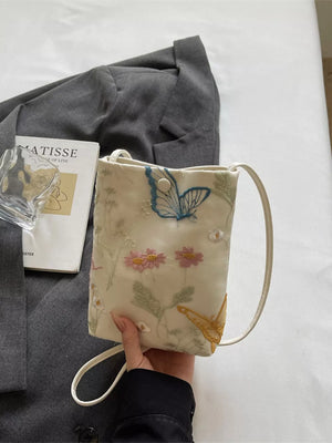 Off-white mini crossbody bag with delicate floral and butterfly embroidery