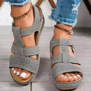 Gray perforated mid-wedge sandals with adjustable strap and comfortable cushioning.