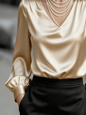 Apricot satin V-neck long sleeve blouse with ruched cuffs, styled with pearls