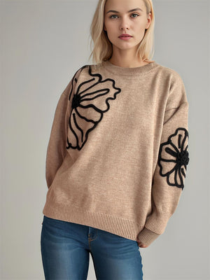 Tan knit sweater with black floral embroidery on sleeves and chest, crew neck, long sleeves.