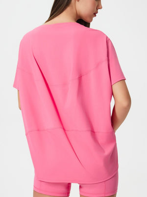 Relaxed fit performance tee in fuchsia pink with short sleeves and seam details.