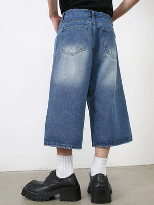 Wide-leg denim culotte shorts in blue wash with distressed hem.