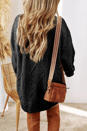 Black cable knit sweater dress with diamond pattern detail and long sleeves.